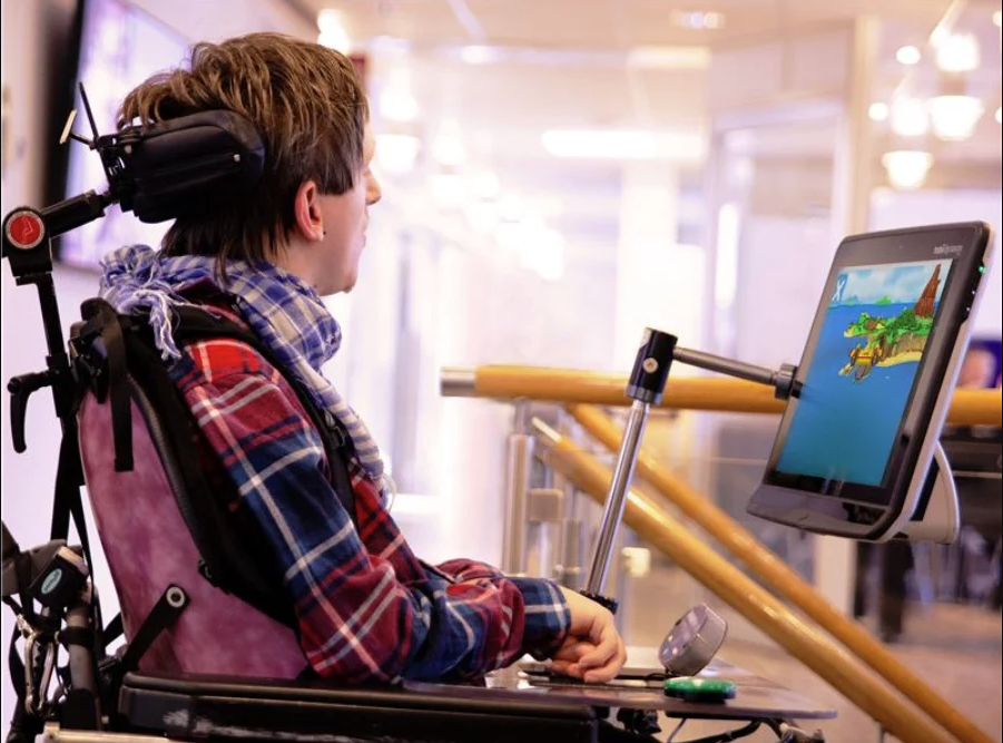 En ung mand med cerebral parese bruger et øjenstyret enhed fra Tobii Dynavox til at spille spil.