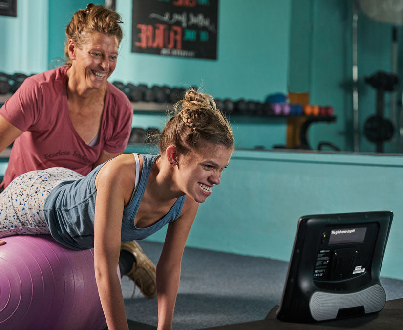 Kvinde, der bruger sin Tobii Dynavox I-Series hjælpeteknologi i fitnesscentret